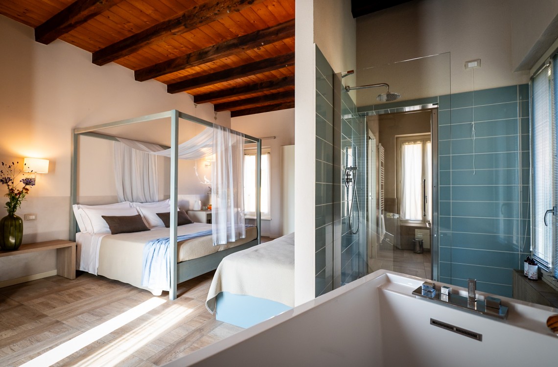 Disposta in modo da regalare ai nostri fortunati clienti una splendida vista sul Canal Grande (Naviglio) che circonda l'antica struttura del casale. Immersa in un ambiente caldo ed elegante, questa suite è stata progettata per farvi rilassare e godere al meglio delle vostre vacanze. Eccezionalmente dotata di ogni comfort possibile. La suite, con i suoi 39 m², deve la sua unicità alla presenza di un comodo letto a baldacchino e di una speciale vasca, dotata di idromassaggio e cromoterapia, che offre una vista spettacolare sui magici dintorni. Inoltre, il divano può essere trasformato in un comodo terzo letto.