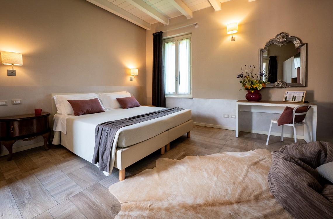 Disposta al primo piano, lungo il balcone aperto sul cortile, offre un ampio spazio, per un totale di 33 m². La Superior Melograno è una camera luminosa ed elegantemente arredata; pensata per regalare alla vostra esperienza di vacanza la migliore sensazione di benessere, anche grazie a tutti i suoi comfort di ultima generazione. Questa camera gode di una splendida vista sugli edifici circostanti e sulla nostra magica campagna.