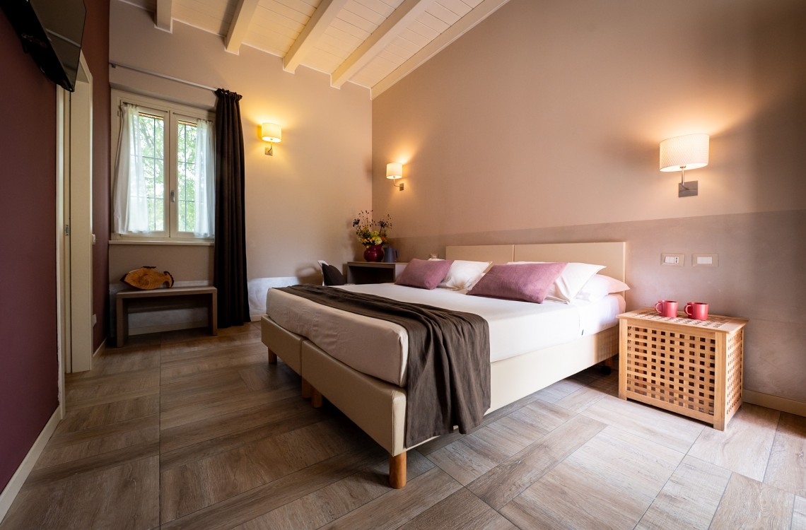 Situata al piano terra dell'edificio che chiude l'antica corte, questa spaziosa e luminosa camera doppia, anche ad uso singola, è la soluzione ideale per trascorrere le vostre vacanze o pernottare durante un viaggio di lavoro. Con una superficie totale di circa 30 mq, è arredata in stile elegante e contemporaneo e dotata di comfort di ultima generazione. Questa camera gode di una splendida vista sugli edifici circostanti e sulla nostra magica campagna.