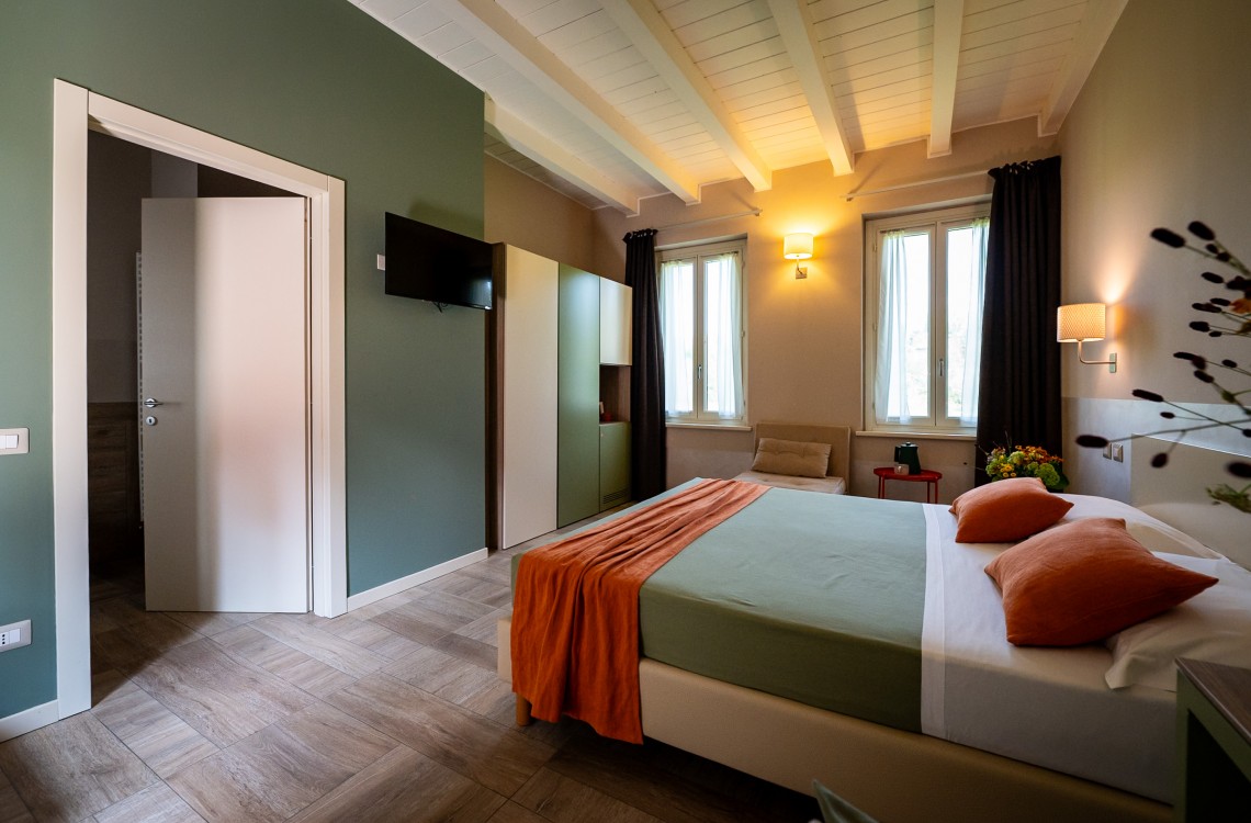 Disposta al piano primo dell'edificio lungo la balconata aperta verso la corte interna, camera doppia con letto matrimoniale, anche ad uso singolo, ampia e luminosa e stata pensata per essere il luogo ideale dove trascorrere il vostro soggiorno di vacanza o di lavoro. Di complessivi 30mq circa, è arredata con stile contemporaneo, caldo ed elegante, dispone di scrivania e confort di ultima generazione. Gode ​​di una bellissima vista sugli edifici circostanti e sulla campagna. <br>Con letto matrimoniale, disponibile uso SINGOLA e uso DOPPIA<br>