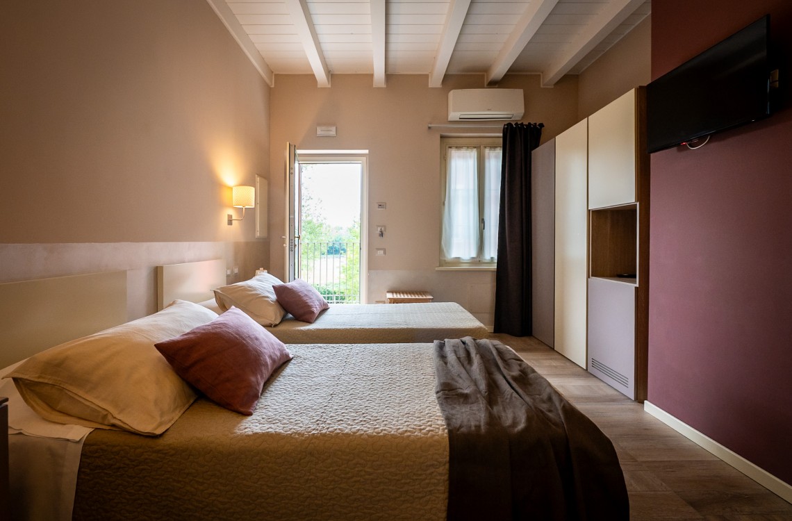 Disposta al piano primo dell'edificio lungo la balconata aperta verso la corte interna, camera doppia, anche ad uso singolo, ampia e luminosa è stata pensata per essere il luogo ideale dove trascorrere il vostro soggiorno di vacanza o di lavoro.  Di complessivi 30mq circa, è arredata con stile contemporaneo, caldo ed elegante, dispone di scrivania e confort di ultima generazione. Gode ​​di una bellissima vista sugli edifici circostanti e sulla campagna. <br>Con letto matrimoniale o due letti singoli, disponibile uso SINGOLA e uso DOPPIA<br>