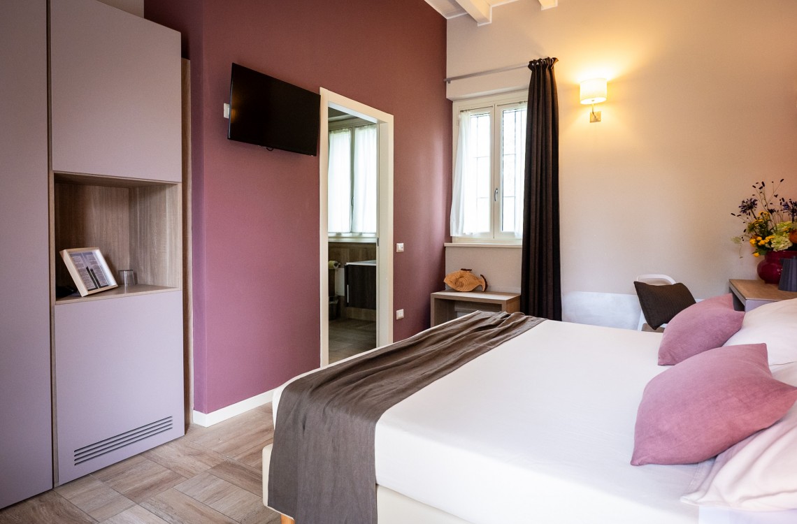 Disposta al piano terra dell'edificio che chiude l'antica corte, camera doppia, anche ad uso singolo, ampia e luminosa è stata pensata per essere il luogo ideale dove trascorrere il vostro soggiorno di vacanza o di lavoro. Possibilità di letto matrimoniale o due letti singoli. Di complessivi 30 mq circa, è arredato con stile contemporaneo, caldo ed elegante, dispone di scrivania e confort di ultima generazione. Gode ​​di una bellissima vista sugli edifici circostanti e sulla campagna. <br>Con letto matrimoniale o due letti singoli, disponibile uso SINGOLA e uso DOPPIA<br>